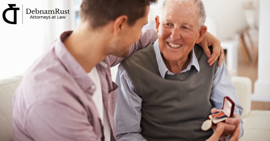 older man and younger man looking at military heirloom and smiling