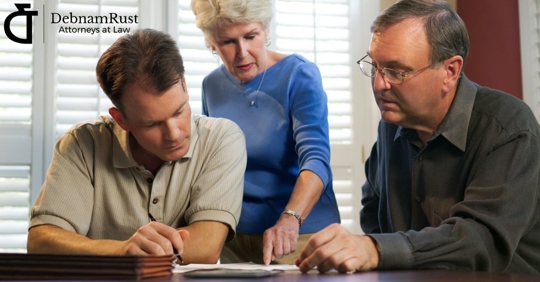 older couple with their middle aged son looking at paperwork