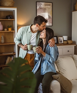 Pink neon sign that reads “and breathe” mounted on a lush green plant-covered wall, creating a calming and peaceful atmosphere