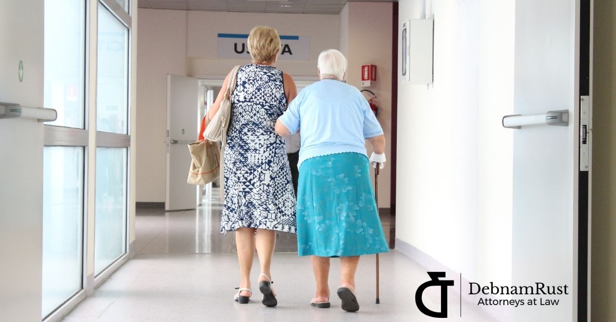 elderly woman and middle age woman walking away down a hallway