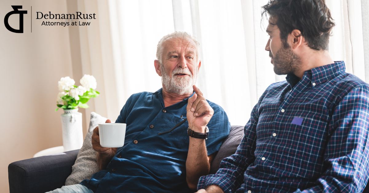 older man talking to adult son on a couch