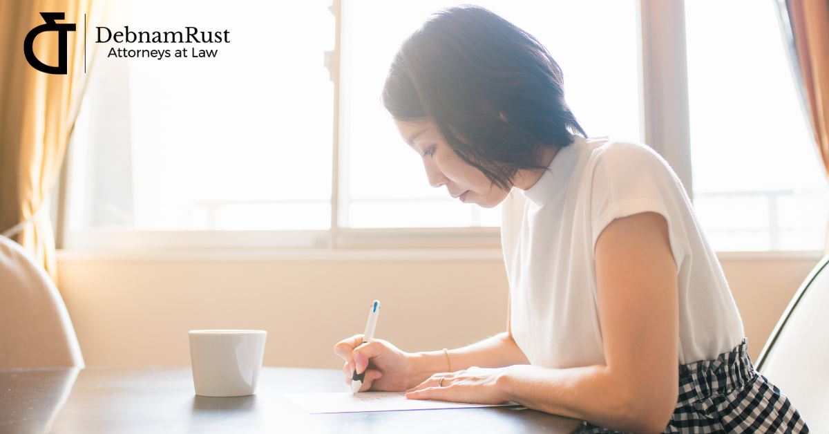 woman writing on paper on a table