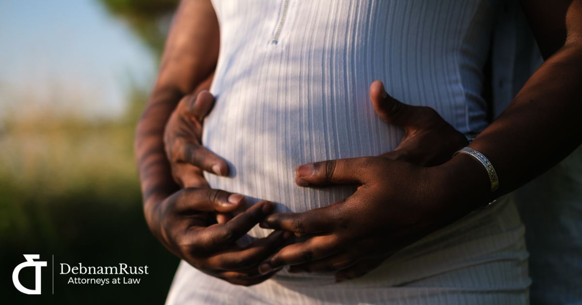 pregnant woman and her partner holding her stomach