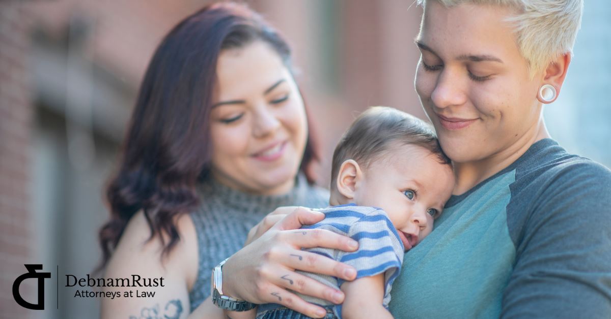 two moms in a same-sex relationship, one holding their child